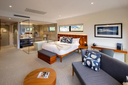 a bedroom with a bed and a living room at Queenstown Park Boutique Hotel in Queenstown