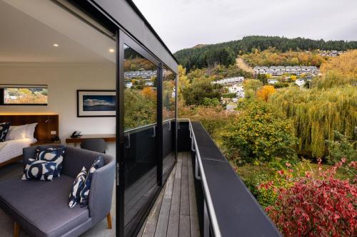 a room with a balcony with a bed and a view at Queenstown Park Boutique Hotel in Queenstown