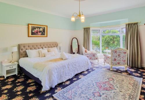 1 dormitorio con cama, espejo y ventana en Rosebank Guesthouse, en Healesville