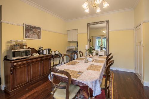 a dining room with a table and a microwave at Rosebank Guesthouse in Healesville