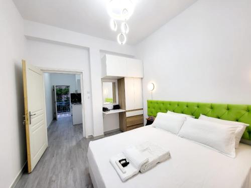 a bedroom with a white bed with a green headboard at AHAMED GREEK SMPCO in Athens