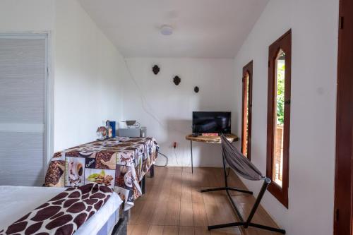 a bedroom with a bed and a desk with a television at Paraiso de la sierra in Santa Marta