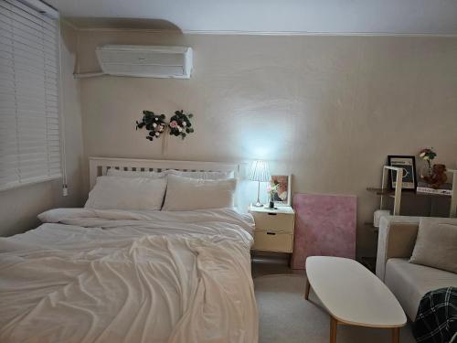 a bedroom with a large bed and a couch at Seoul 리베하우스 3room KSPO-DOM Family trip in Seoul