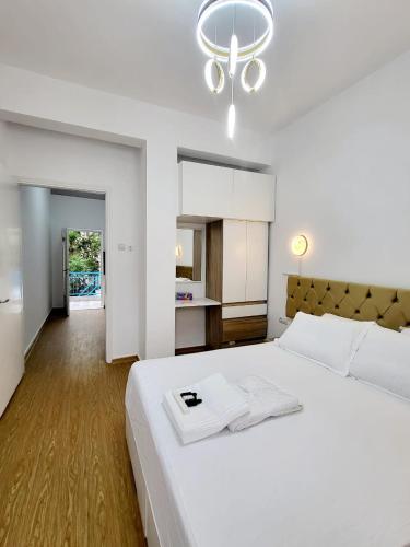 a bedroom with a large white bed with a chandelier at AHAMED GREEK SMPCO in Athens