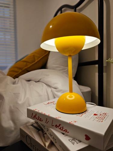 a yellow lamp sitting on top of a book at Seoul 리베하우스 3room KSPO-DOM Family trip in Seoul