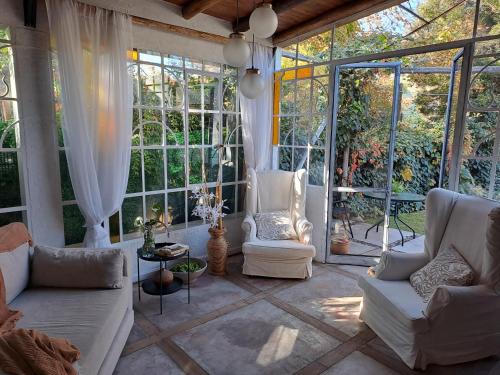 a living room with white furniture and large windows at CASA ADAGIO in Ciudad Lujan de Cuyo