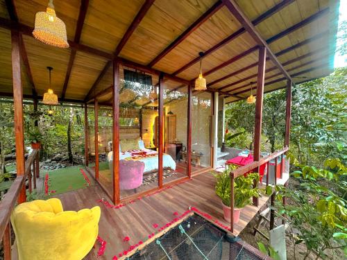 een glazen huis met een bed op een houten terras bij Puyu Glamping in Tarqui