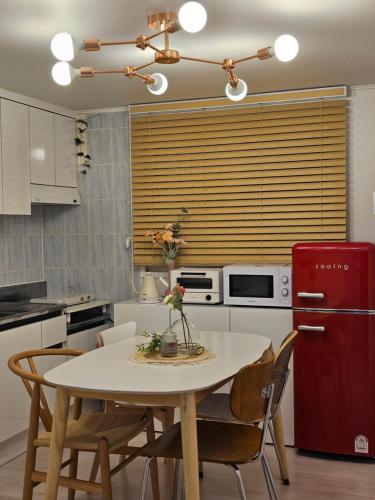 a kitchen with a white table and a red refrigerator at Seoul 리베하우스 3room KSPO-DOM Family trip in Seoul