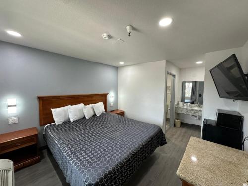 a hotel room with a bed and a flat screen tv at Motel Santa Cruz in Santa Cruz