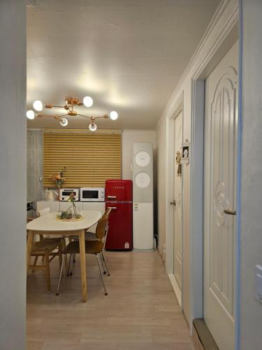 a kitchen with a table and a red refrigerator at Seoul 리베하우스 3room KSPO-DOM Family trip in Seoul