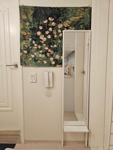 a painting of flowers on a wall next to a mirror at Seoul 리베하우스 3room KSPO-DOM Family trip in Seoul