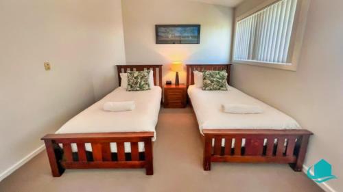 two twin beds sitting in a room with at Beachside Beauty in Caves Beach