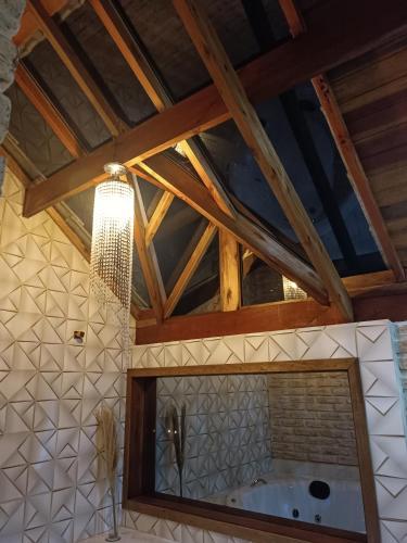 a bathroom with a tub and a wooden ceiling at Pousada rota nas montanhas in Camanducaia