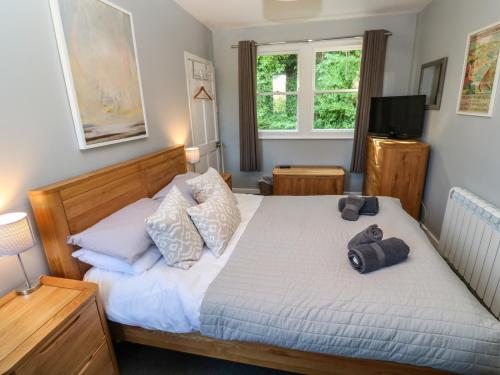 een slaapkamer met een bed en een televisie bij 8 Rosewall Cottages in St Ives