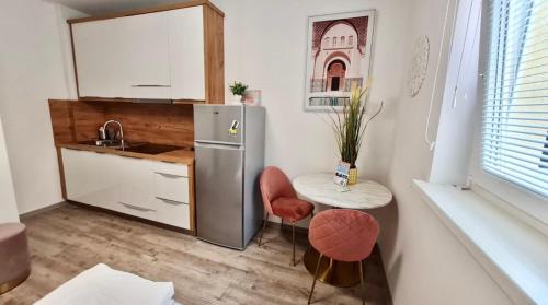 uma pequena cozinha com uma mesa e um frigorífico em Ljubljana Central Studio with Free Parking em Ljubljana
