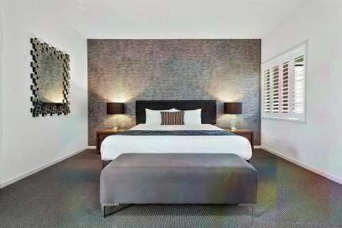 a bedroom with a large bed and a large ottoman at Quality Resort Parkhurst in Rockhampton