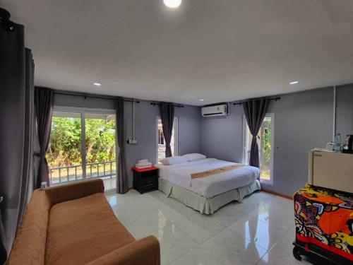 a bedroom with a bed and a couch at family resort in Ko Phayam