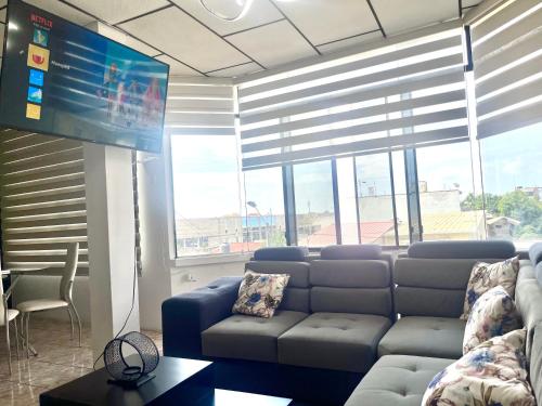 ein Wohnzimmer mit einem Sofa und einem Flachbild-TV in der Unterkunft Moderno, grande, amplia vista, parqueo in Machala