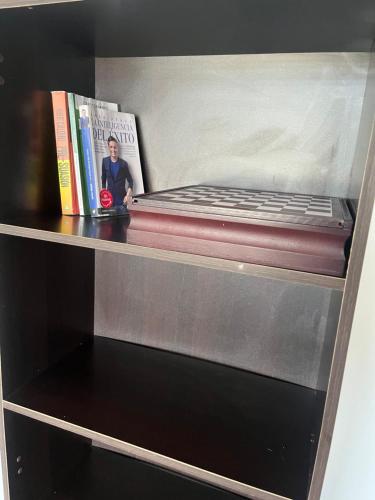 a book shelf with a bed and two books at Moderno, grande, amplia vista, parqueo in Machala