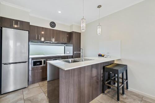 a kitchen with a sink and a refrigerator at Quality Resort Parkhurst in Rockhampton