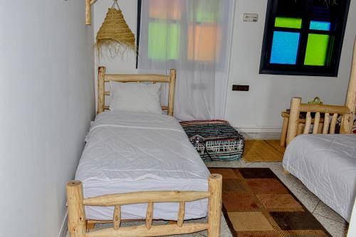 a small bedroom with a bed and a window at Hotel Safari Week-end in Midelt