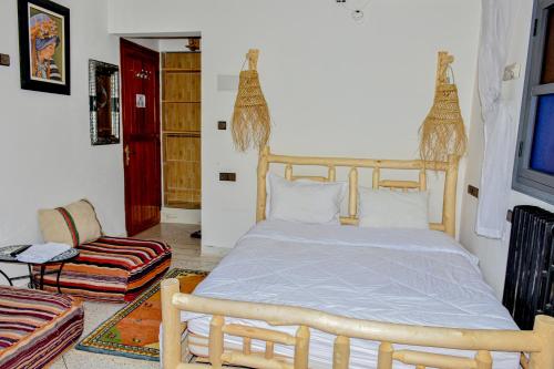 1 dormitorio con 1 cama grande y 1 silla en Hotel Safari Week-end, en Midelt