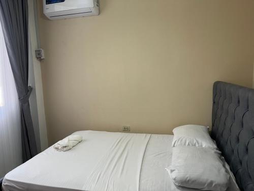 a bed with two pillows on it in a room at Moderno, grande, amplia vista, parqueo in Machala