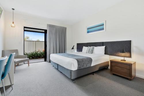 a hotel room with a bed and a desk at Quality Resort Parkhurst in Rockhampton