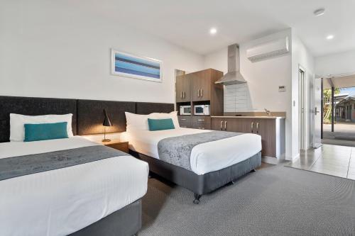 a bedroom with two beds and a kitchen at Quality Resort Parkhurst in Rockhampton