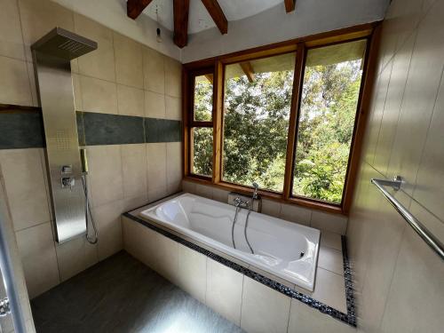 a bath tub in a bathroom with a window at Hacienda Jimenita Wildlife Reserve in Puembo