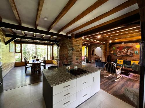 a kitchen and living room with wooden ceilings and a table at Hacienda Jimenita Wildlife Reserve in Puembo