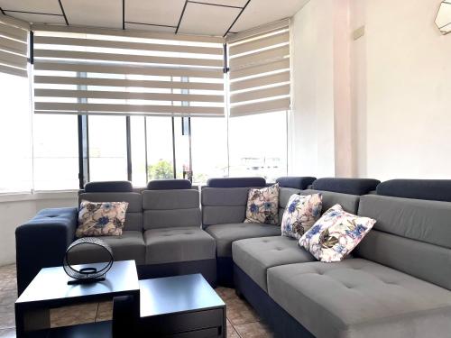 a living room with a couch and a table at Moderno, grande, amplia vista, parqueo in Machala