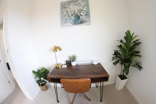 a dining room with a wooden table and plants at New 4 Bedroom Home with Ocean and Gorgeous Mountain Views in the gated community of Mauna Olu in Waianae