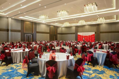 a large banquet hall with tables with red bows at Swiss-Belhotel Cendrawasih, Biak in Fandoi