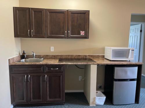 a kitchen counter with a sink and a microwave at Diplomat Motel in Nanaimo