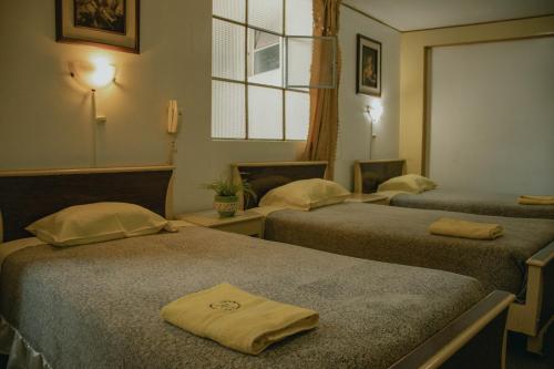 um quarto de hotel com duas camas e uma janela em Hotelˈs Acolla em Huancayo