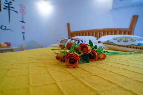 a bunch of flowers on a yellow bed at Easy House in Zhangjiajie