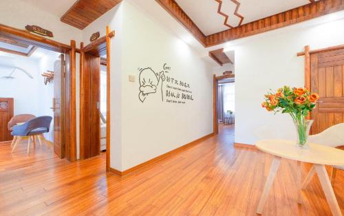 a room with a table and a vase of flowers on a wall at Easy House in Zhangjiajie