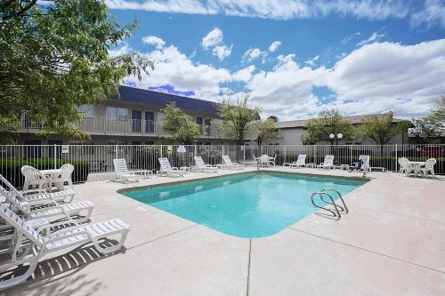 une piscine avec des chaises longues et une piscine dans l'établissement Motel 6-Holbrook, AZ, à Holbrook