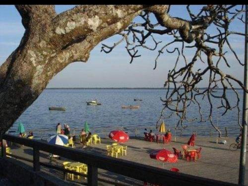 a beach with tables and umbrellas on the water at Casa de luxo c/piscina 4 quartos 2 banheiras. in Rio de Janeiro