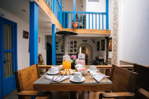 mesa de comedor con plato de comida y zumo de naranja en La Casa de Mayte, en Cusco