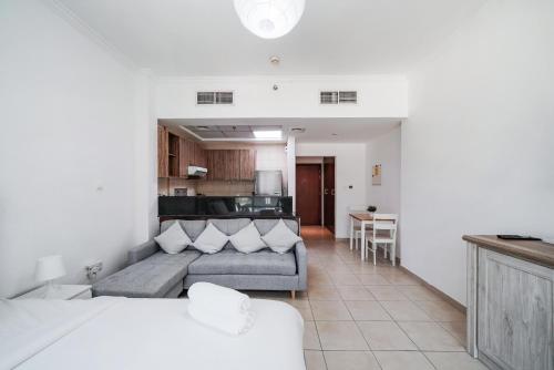 a living room with a couch and a kitchen at Studio close to Burj Khalifa and Downtown Dubai in Dubai
