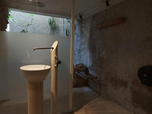 y baño con aseo y lavamanos. en Elmar hostal en Bacalar