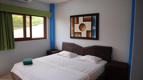a bedroom with a bed and a window at Hotel Sol y Playa Montañita in Montañita