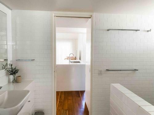 a white bathroom with a sink and a shower at Peregian House - beach front property in Peregian Beach