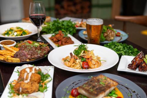 a table with plates of food and a glass of beer at Australian Hotel Motel Yass in Yass
