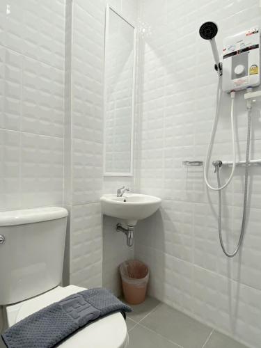 a bathroom with a shower and a toilet and a sink at Ladakul hostel (ลดากุลโฮสเทล) in Chom Thong