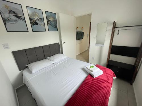 a bedroom with a white bed with a red blanket at FlyNow Studios - Aeroporto Sp Expo Metrô in Sao Paulo
