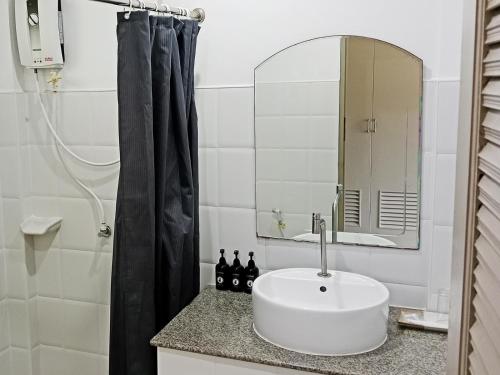 La salle de bains est pourvue d'un lavabo blanc et d'un miroir. dans l'établissement Ampha Place Hotel, à Mae Nam Beach