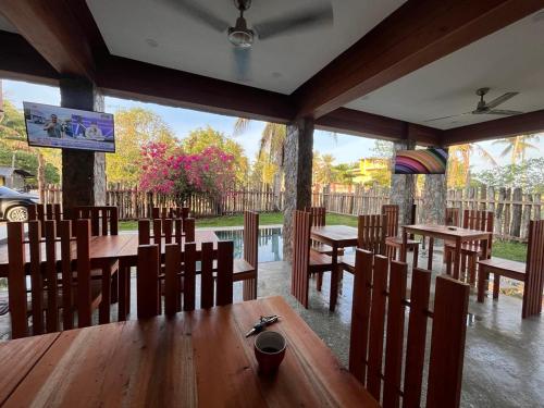a restaurant with wooden tables and chairs and a screen at Tabularasa - T Palawan in San Vicente